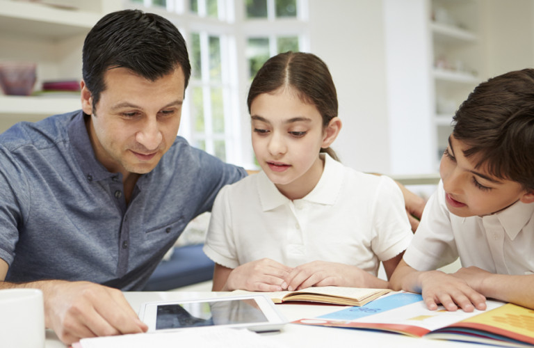 A father helping his children through their homework