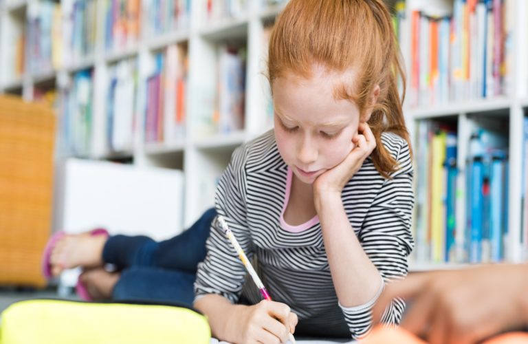 Female student reading at the library.