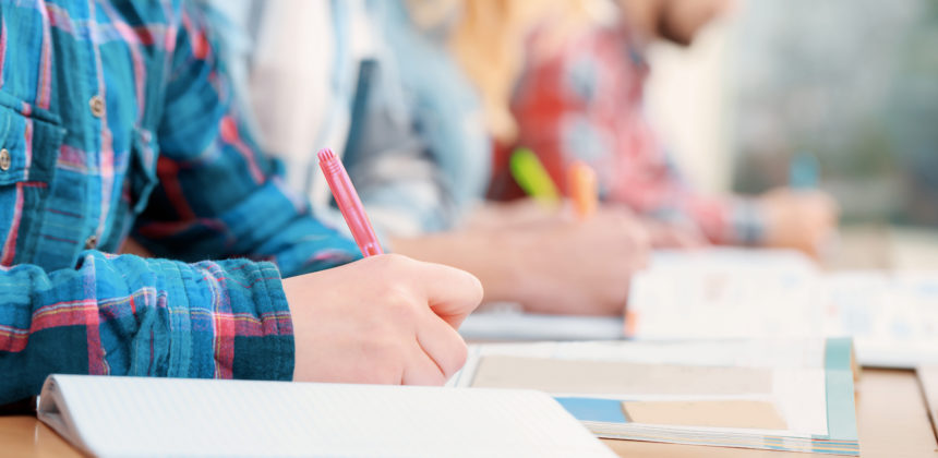 Close up of students taking notes in class