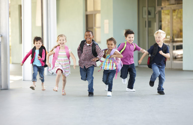 Group Of Elementary Age Schoolchildren Running Outside