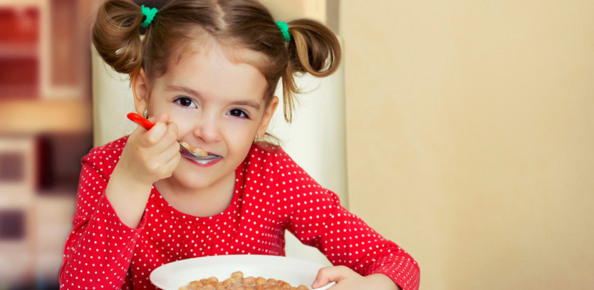 A little girl eating cereal for breakfast