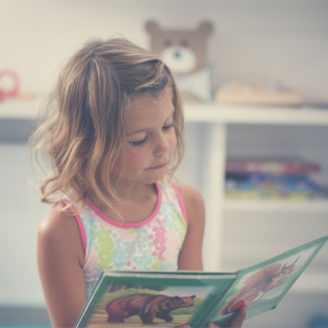 A young girl reading a book.