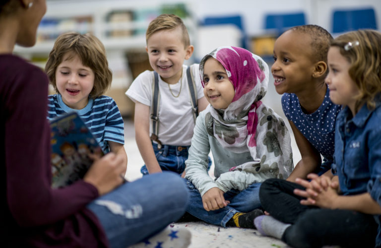 Children listen intently as their teacher reads to them