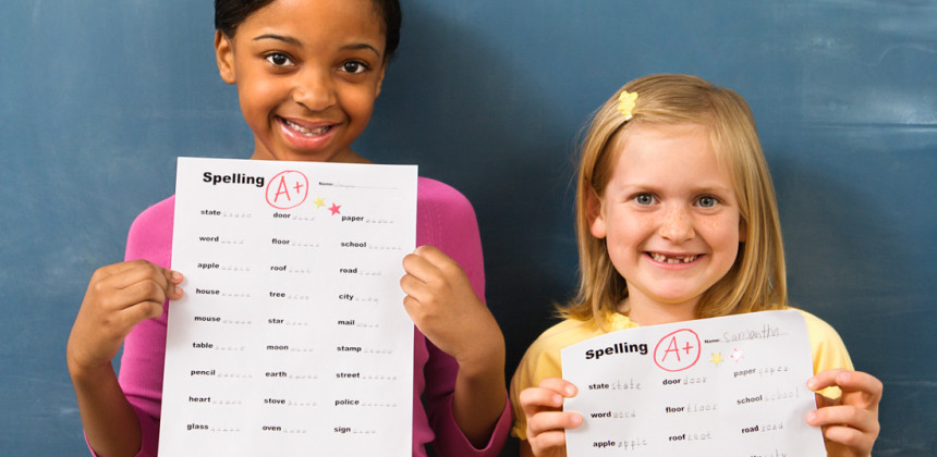 Little girls holding up their report cards